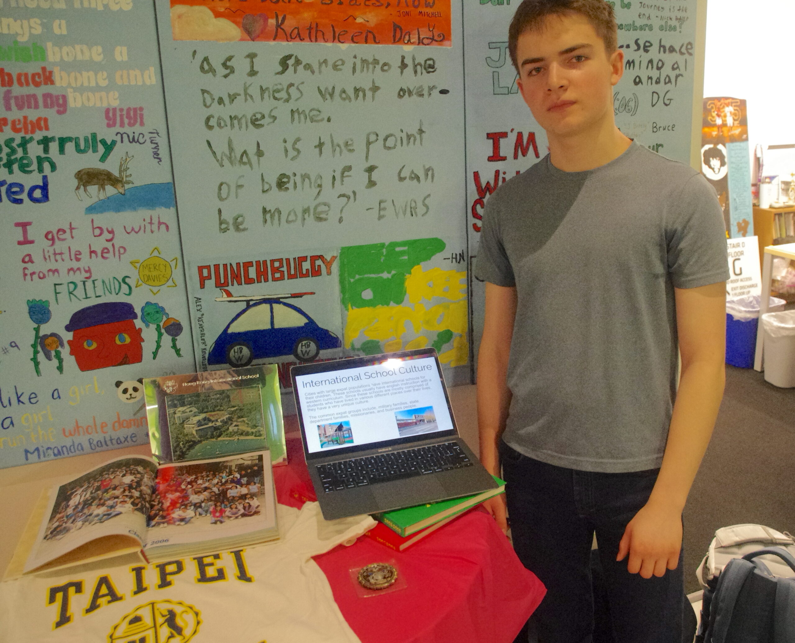 Student standing in front of his culture display