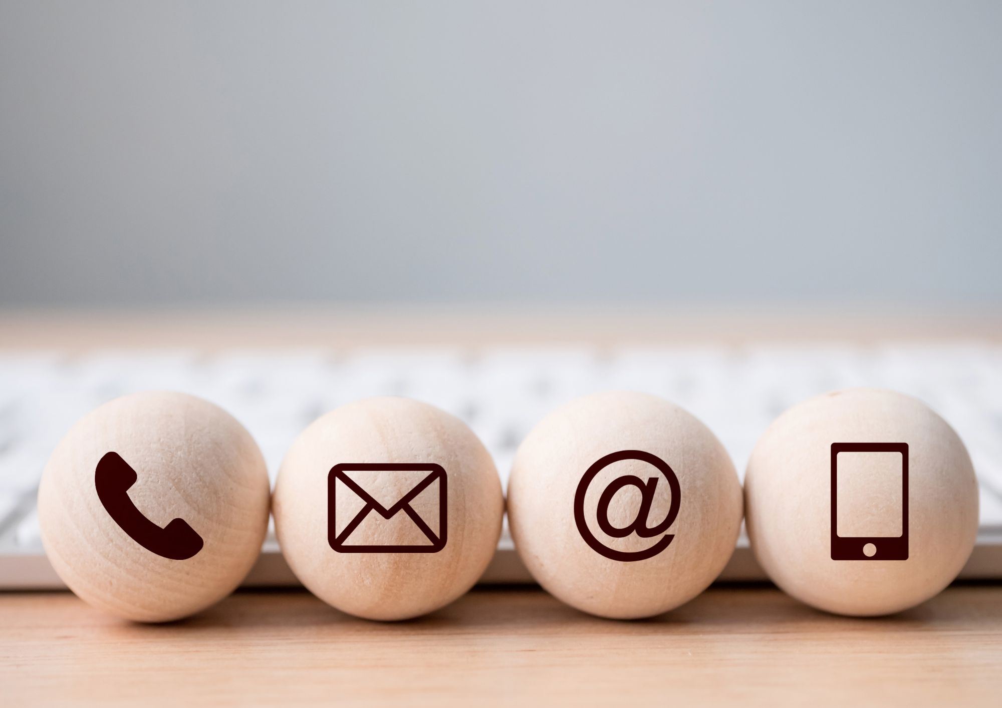 Wooden Balls with a telephone, letter, @ symbol, and cellphone