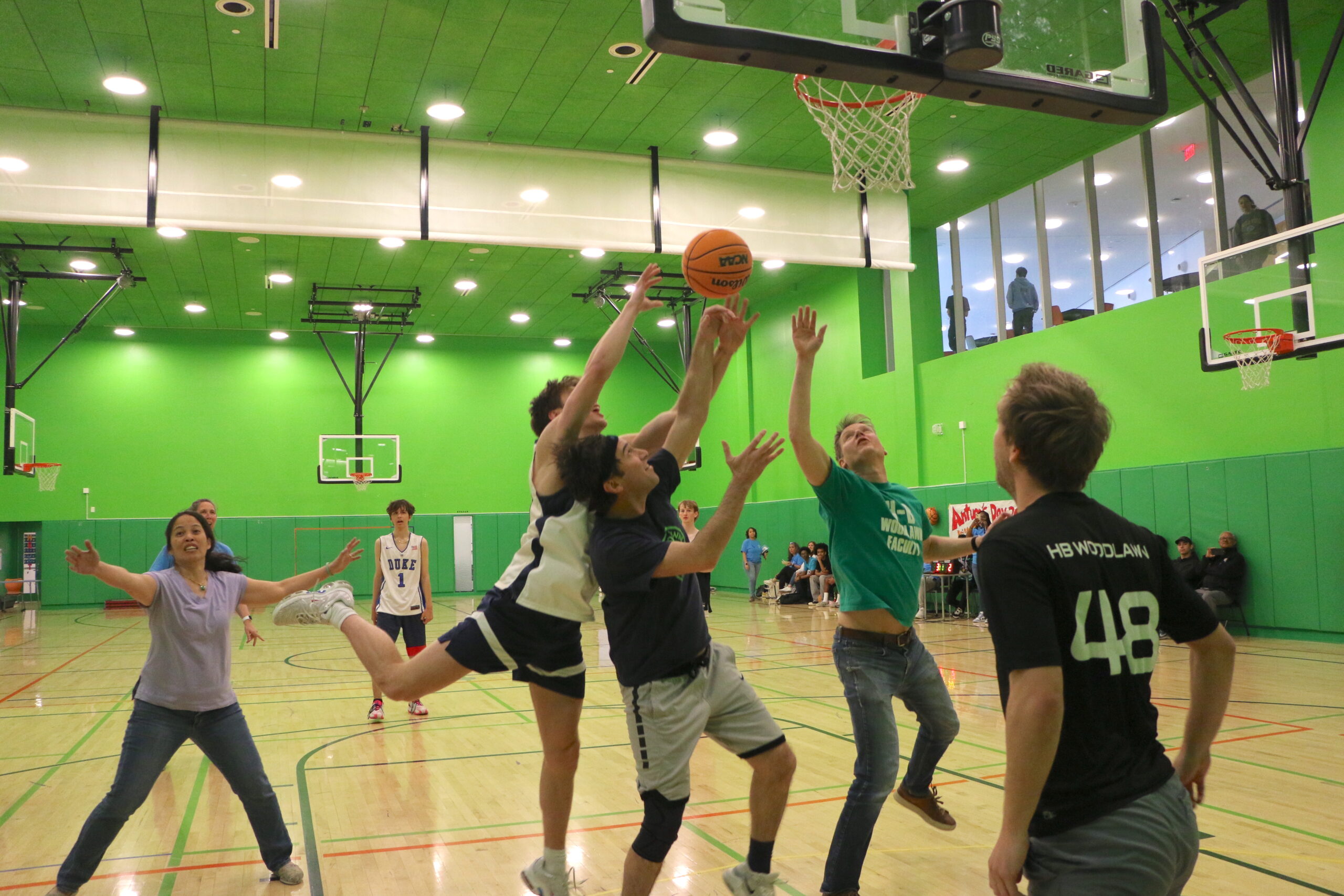 Students and teachers playing a basketball game