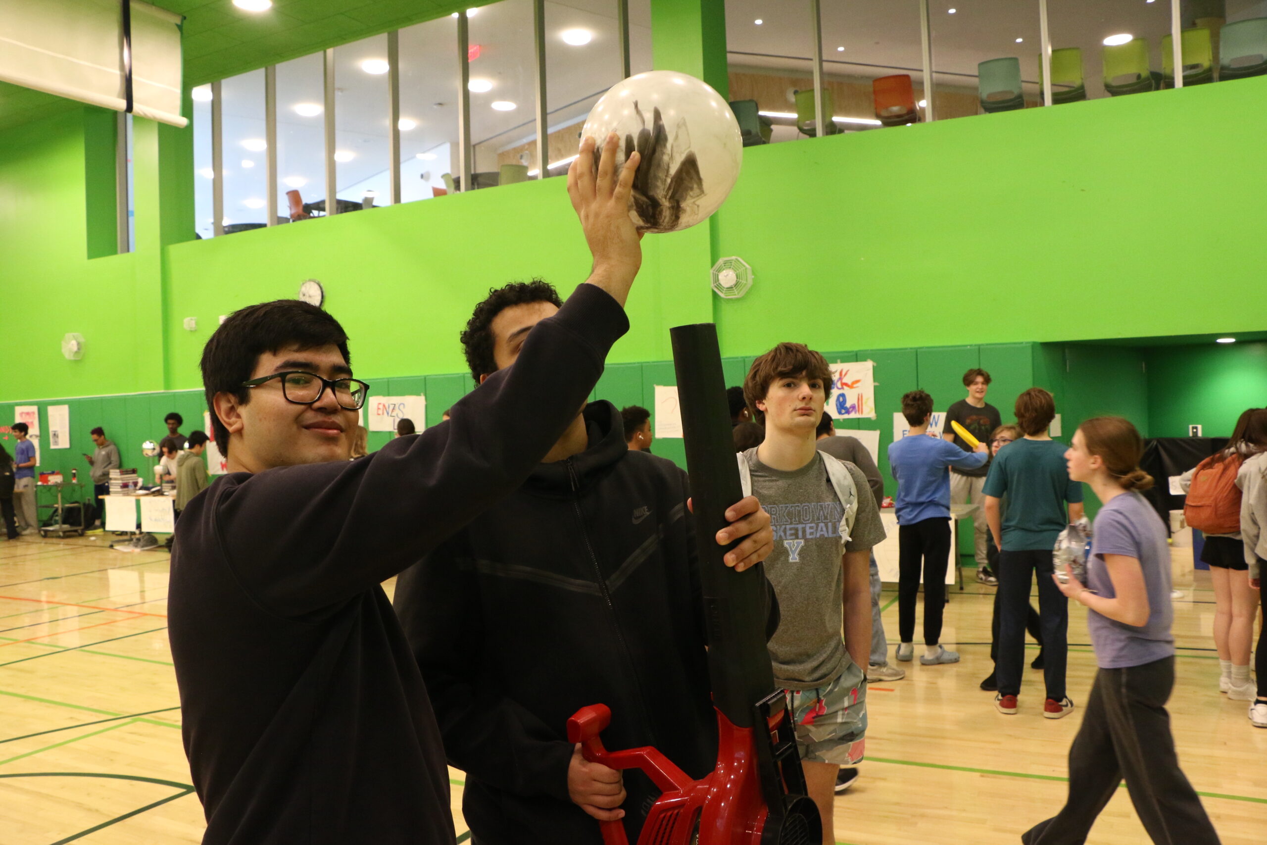 Student holding a ball above his head