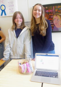 Two female students standing in front of a presentation