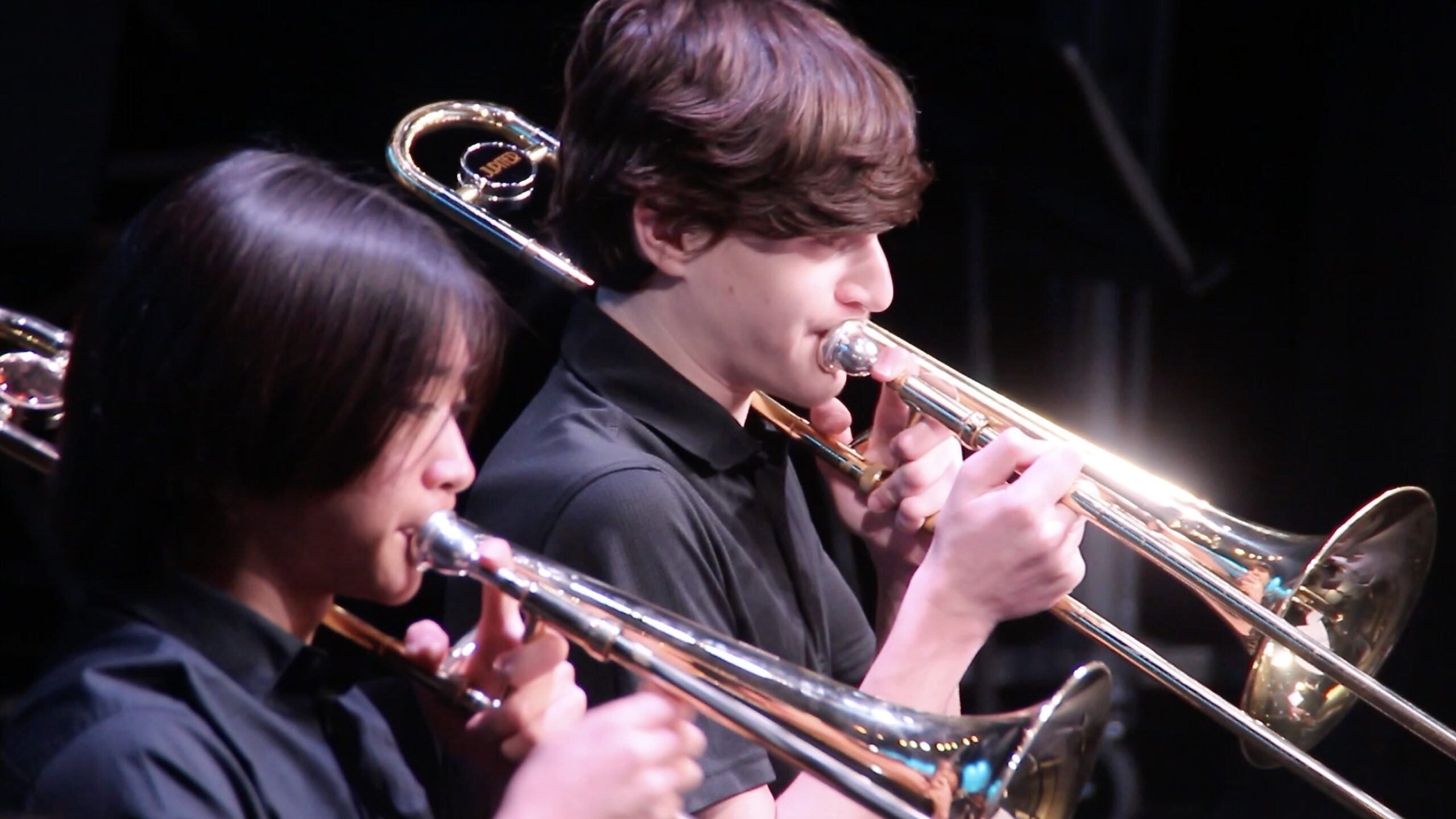 Two students playing trombone