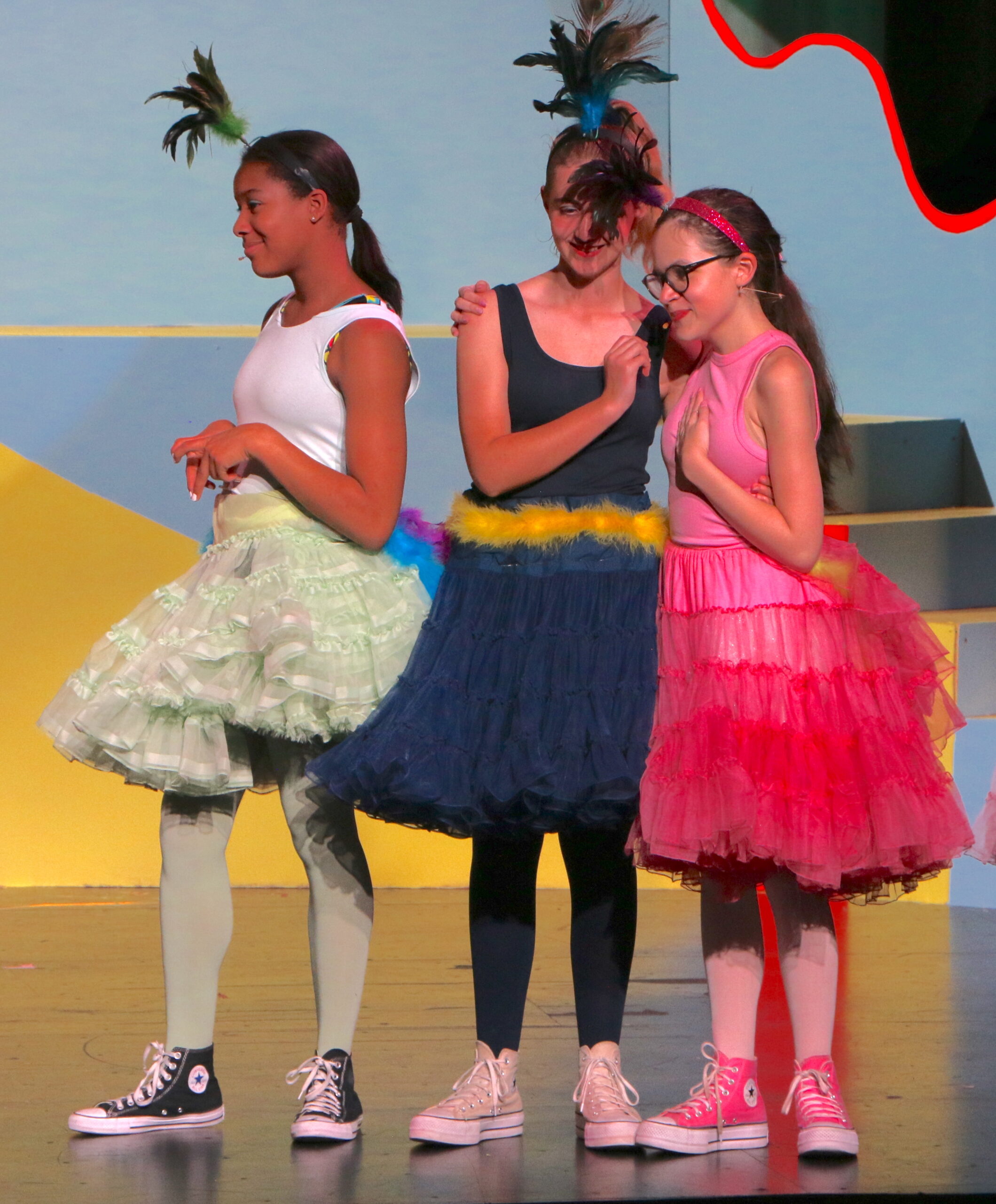 Three students performing on stage
