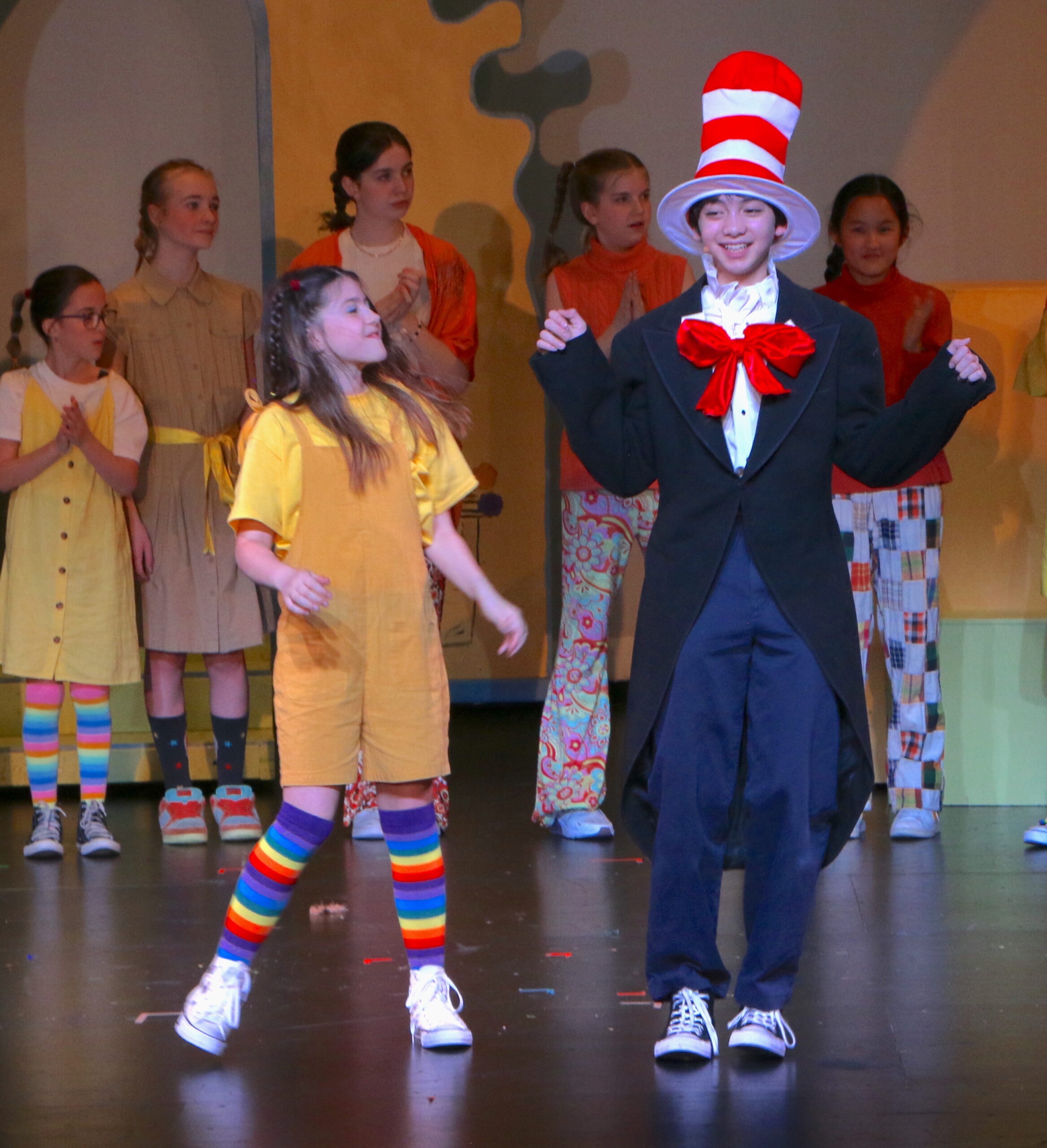 Students performing on stage - cat in the hat and a child front and center