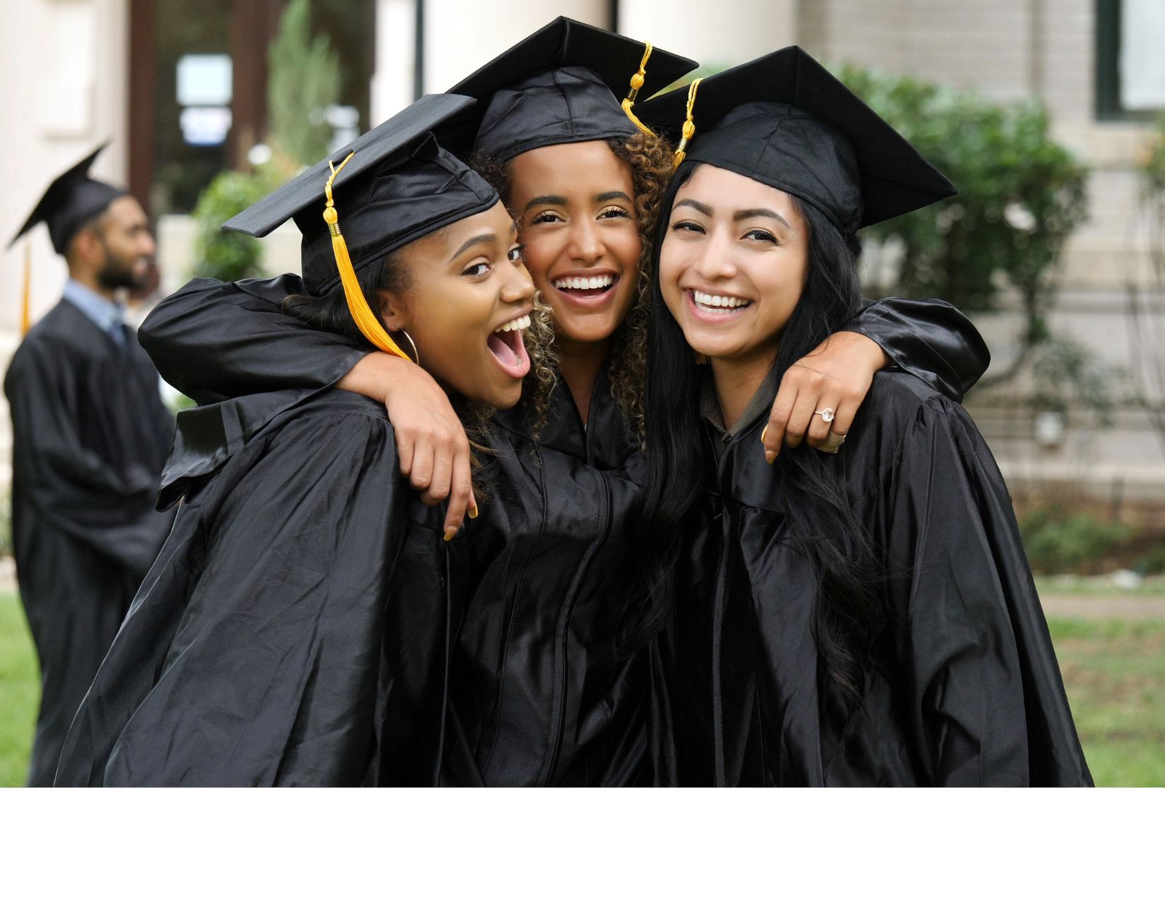 Three students with graduation gowns and hats