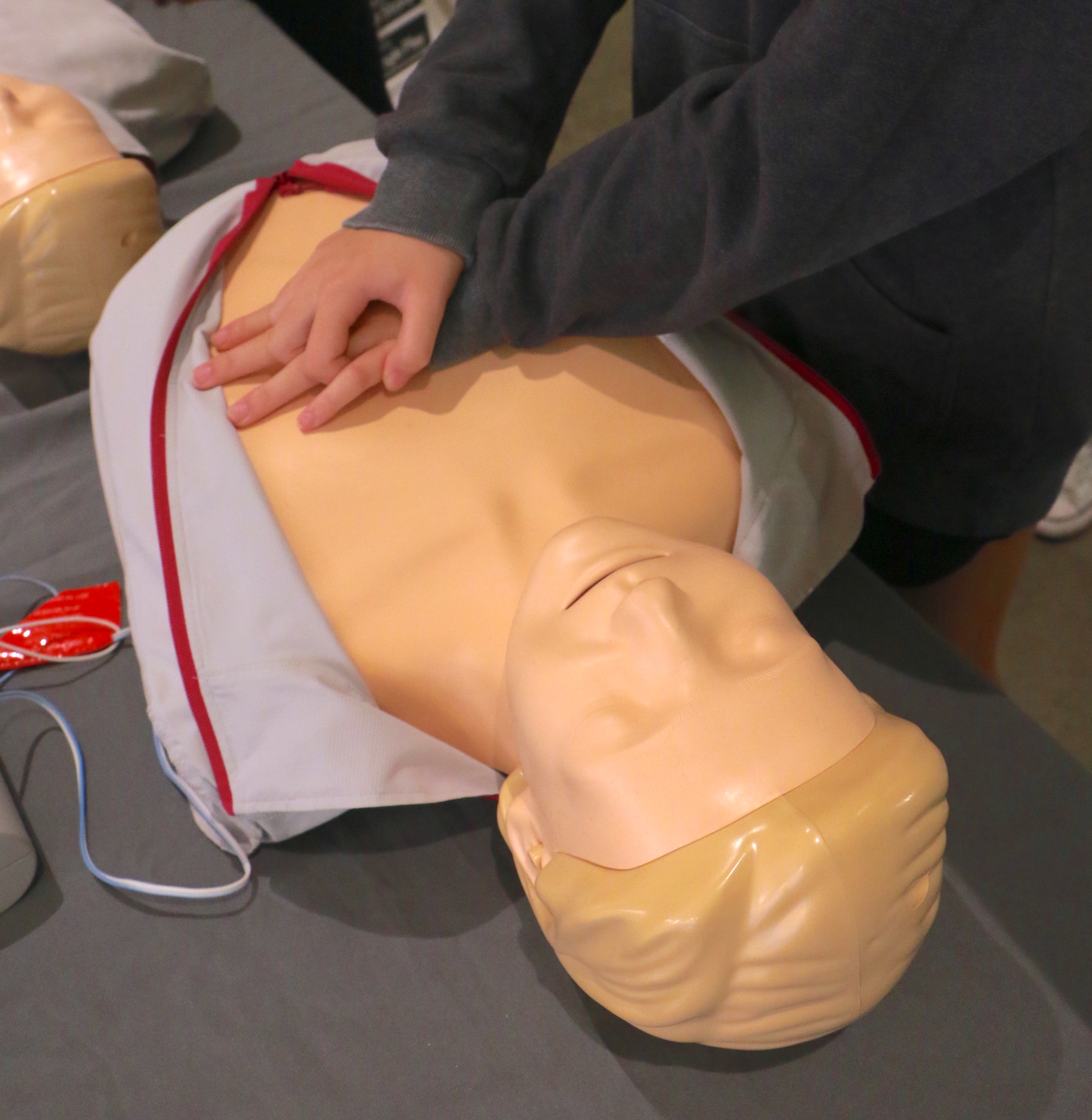 A student practicing CPR on a CPR doll