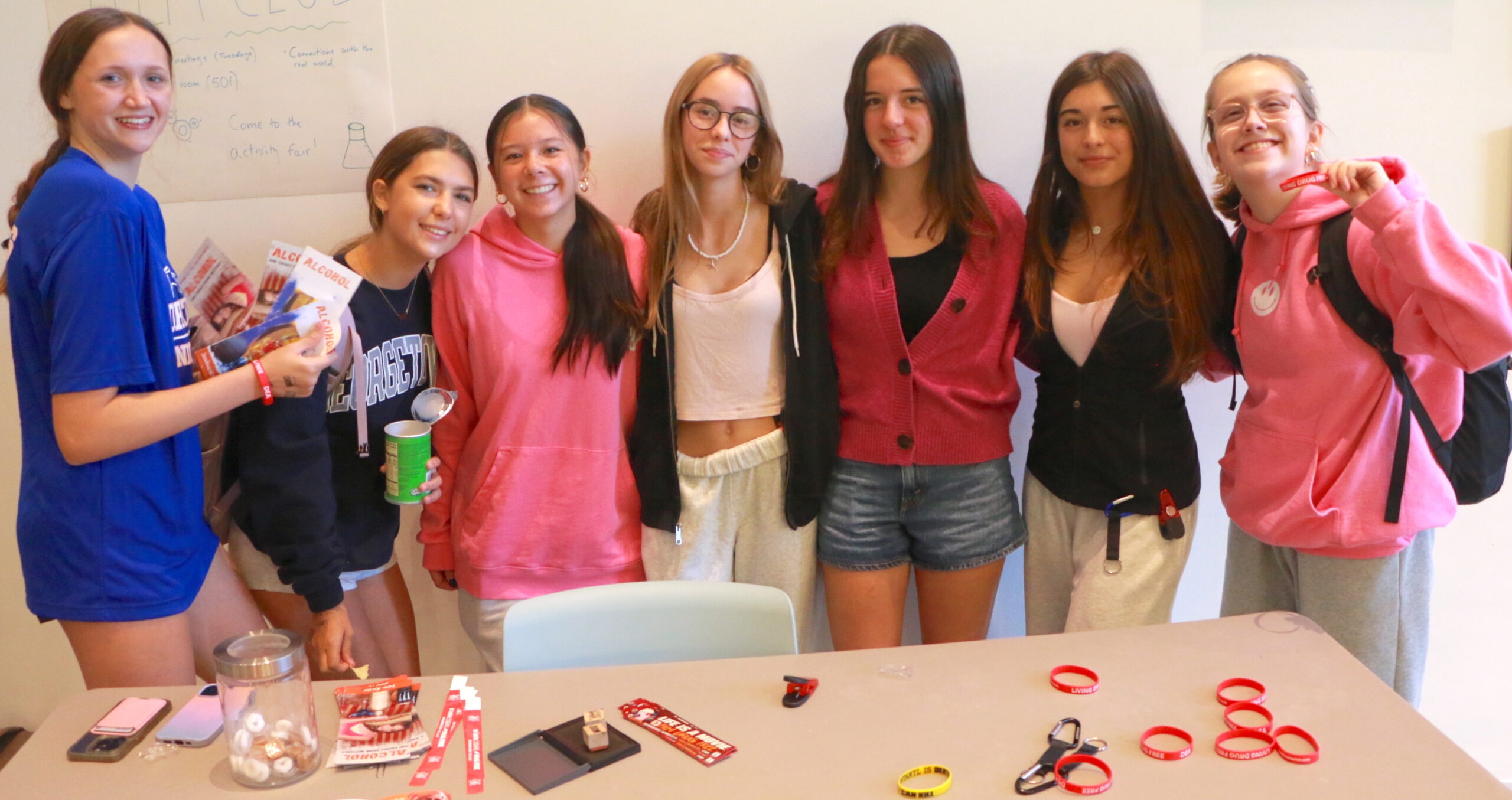 Group of students standing behind a presentation table