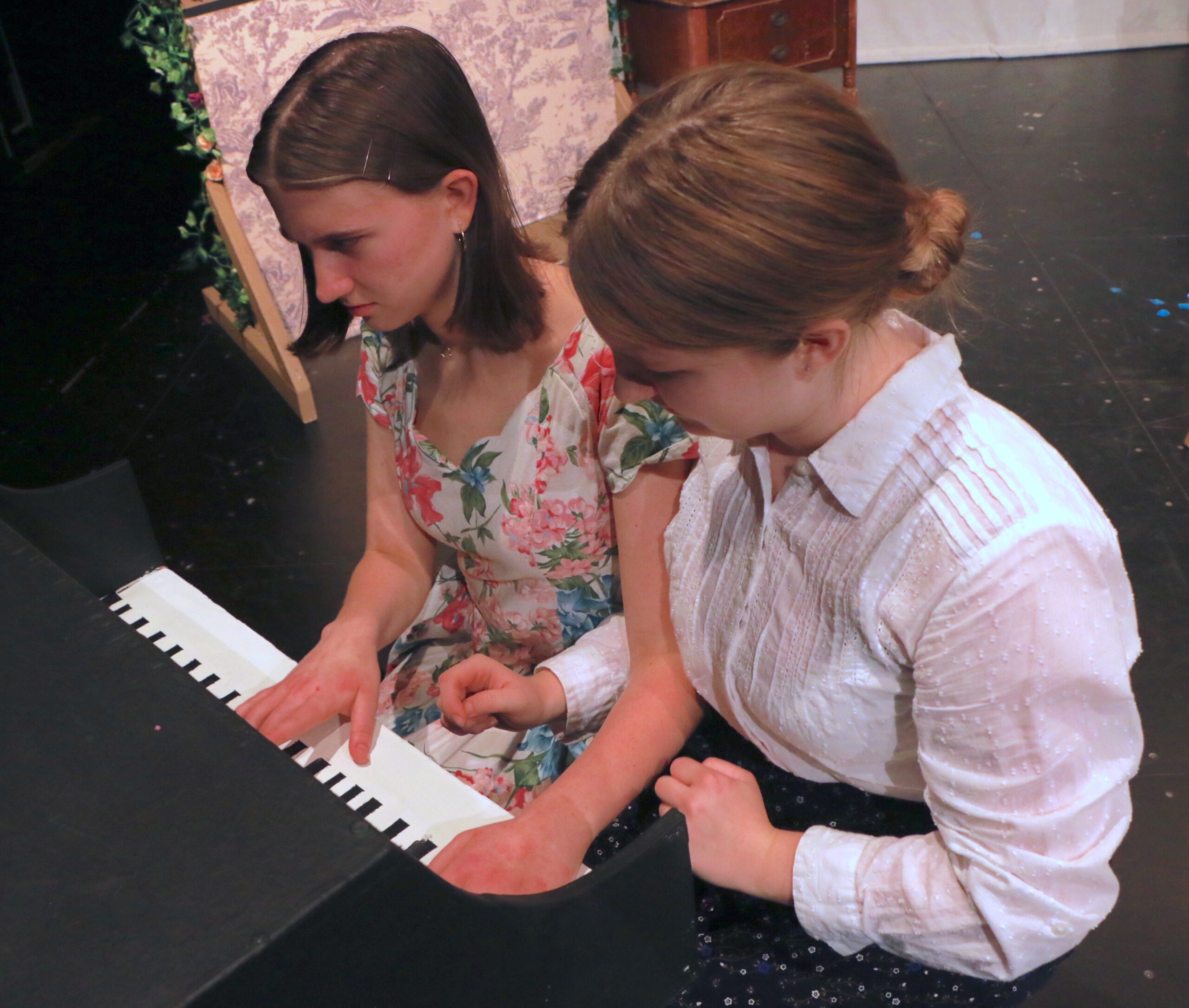 Two people playing the piano