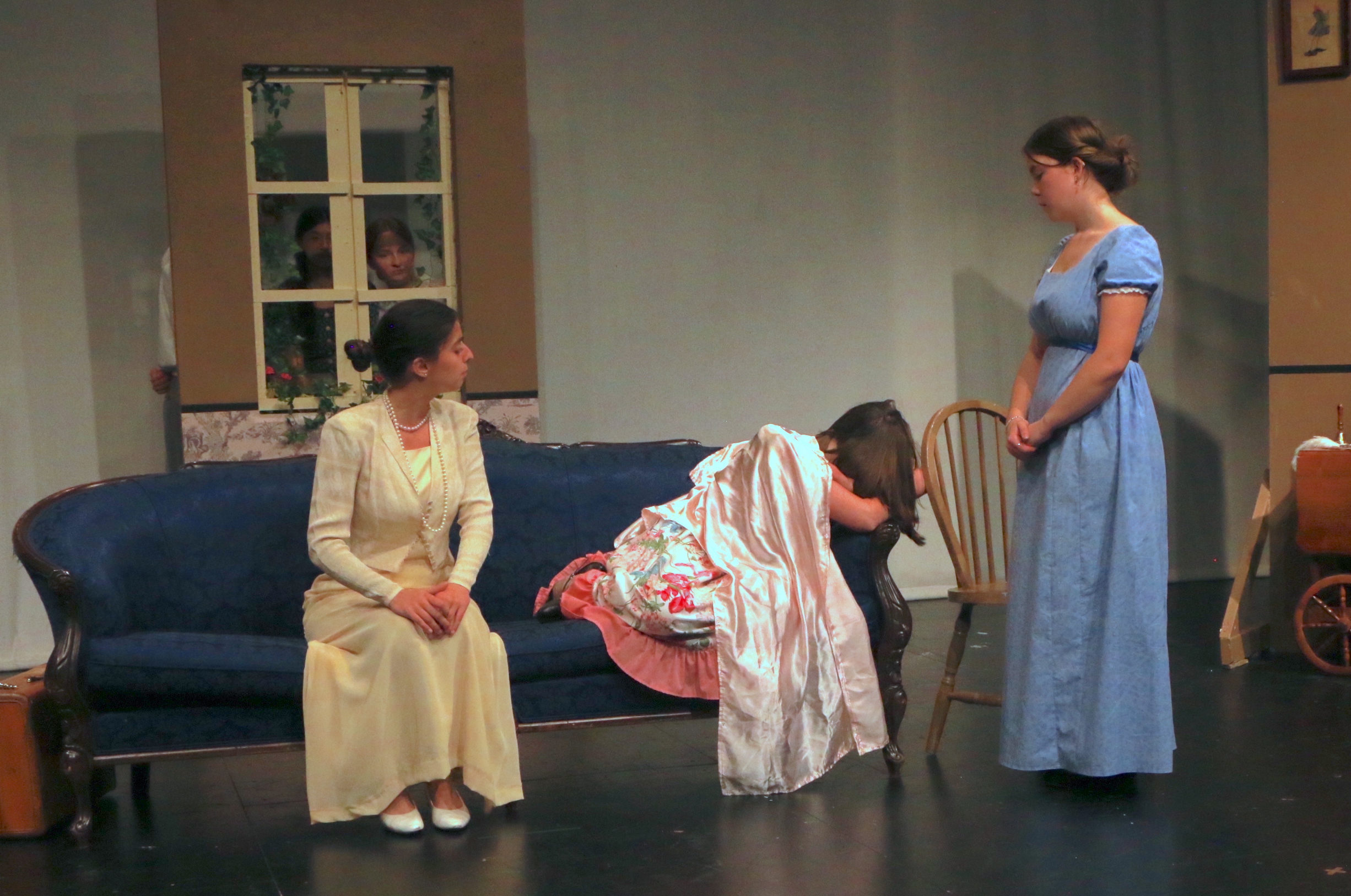 Three women, one crying on couch